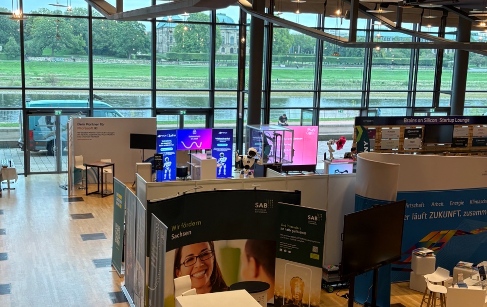 Exhibition floor at the ICD Dresden overlooking the Elbe: the NFON and Zöllner stand, with the Brains on Silicon startup lounge behind it