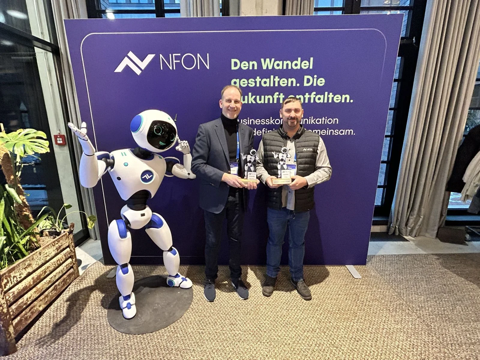 Team mit NFON Roboter und Auszeichnung