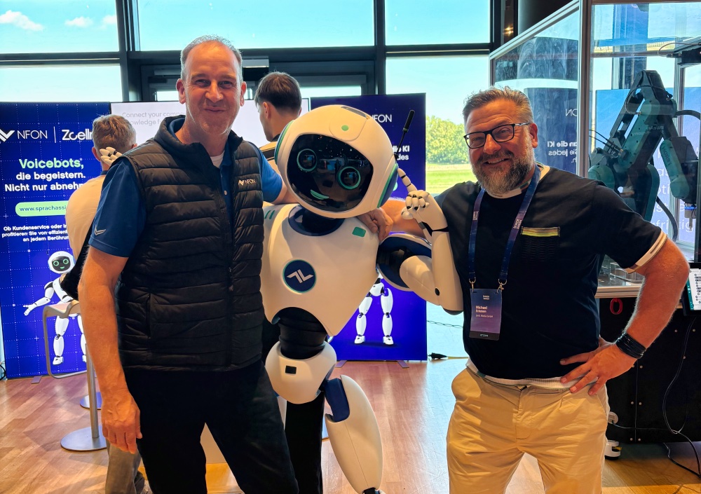 Peter Gemander and Michael Eckstein next to the NFON service robot at the stand at Brains on Silicon 2026