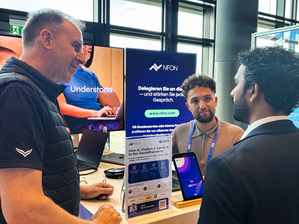 Peter Gemander and Yasin Kizilhan talking to a visitor at the NFON stand at Brains on Silicon 2026
